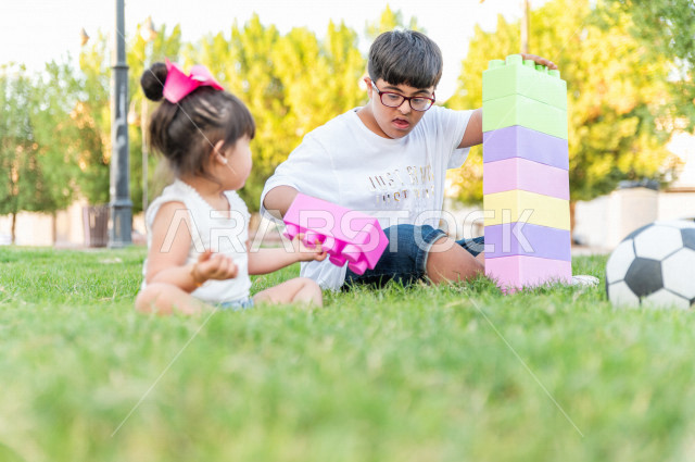 اخ و اخت سعوديان من ذوي الهمم يقضيان وقتهما في اللعب بالمنتزه ، اللعب في الهواء الطلق ، أصحاب الهمم ، ذوي الاحتياجات الخاصة