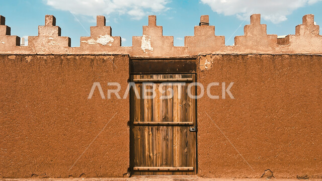 باب خشبي بتصميم معماري عربي قديم، الفن الهندسي المعماري للمباني الطينية القديمة في قرية أشيقر في محافظة الشقراء، البيوت الأثرية التاريخية في مدينة الرياض، أماكن سياحية تراثية مشهورة في السعودية