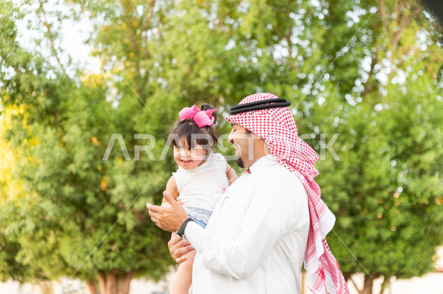 فتاه جميلة مصابة بملازمة داون تقضي وقتها في نزهه مع والدها بالمنتزه ، اب سعودي خليجي يلعب مع ابنته في الهواء الطلق ، أصحاب الهمم ، ذوي الاحتياجات الخاصة