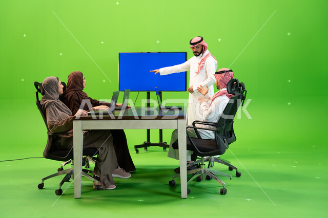 ورشات عمل وتدريب للموظفين بواسطة شاشة زرقاء فارغة، متابعة ومناقشة إستراتيجيات وأهداف الشركة, بورتريه لفريق عمل عربي خليجي سعودي على طاولة الإجتماع داخل مقر الشركة، دراسة وتحليل المشاريع الجديدة باستخدام جهاز التابلت ، خلفية خضراء, كروما