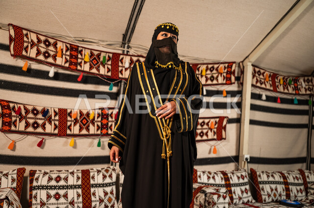 الاعتزاز والفخر بالهوية الوطنية، ذكرى يوم التأسيس السعودي في 22 فبراير، ارتداء أزياء أهل المنطقة الوسطى، إمرأة عربية سعودية خليجية  ترتدي العباءة و البرقع تنظر إلى شيء ما، تأسيس الدولة السعودية الأولى 1727 م