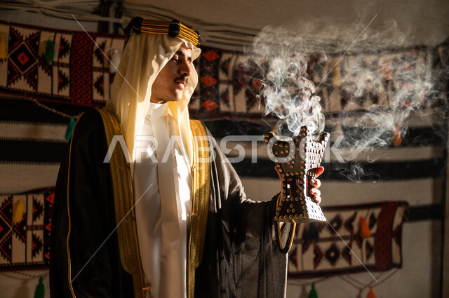 Using agarwood to perfume with incense, fumigation and perfume to celebrate the Founding Day, February 22, distinctive Saudi aromatic scents, close-up photo from the side of a Saudi Gulf Arab man wearing a ghutra and bisht, fumigating himself using the incense burner, the founding of Saudi Arabia in 1727 AD, following the heritage of the ancestors and their customs