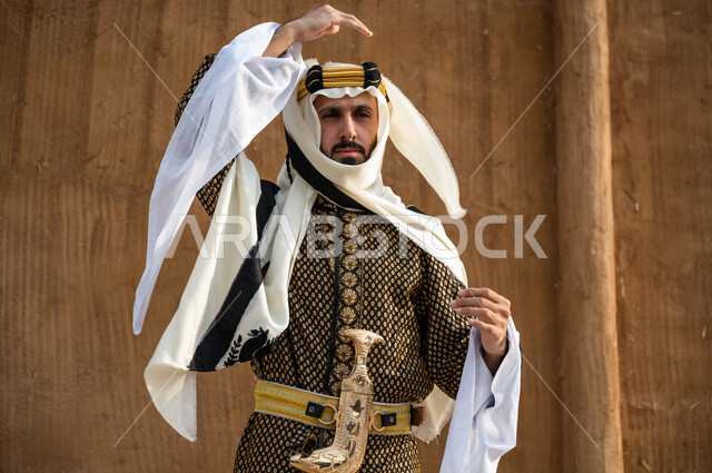 ذكرى تأسيس المملكة 1727, إبراز روح الانتماء للوطن, صورة مقربة لرجل عربي خليجي سعودي يرتدي الدقلة والعقال الذهبي ويقوم بتعديل الغترة, ارتداء الأزياء الشعبية والمحزم,  يوم التأسيس ٢٢ فبراير, الاعتزاز بامتلاك الجنبية التراثية, الاهتمام بالمظهر الخارجي