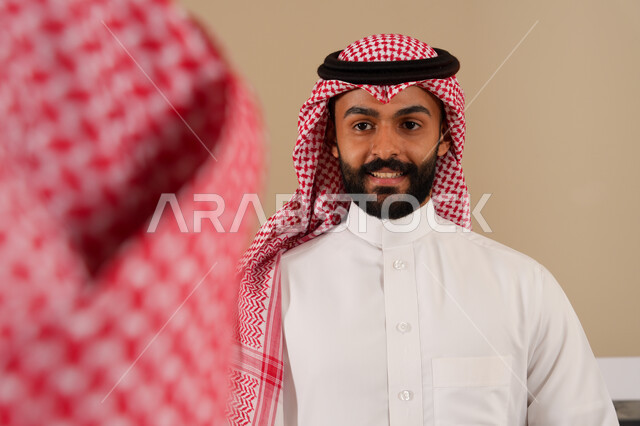 اجراءات الحجز والدخول في مكتب الاستقبال, خدمة العملاء في الفنادق السياحية, شاب عربي خليجي سعودي يرتدي الثوب والشماغ يعمل في مجال الاستعلامات, ارتداء الزي السعودي التقليدي, الاستعلام والاستفسار عن الخدمات الفندقية