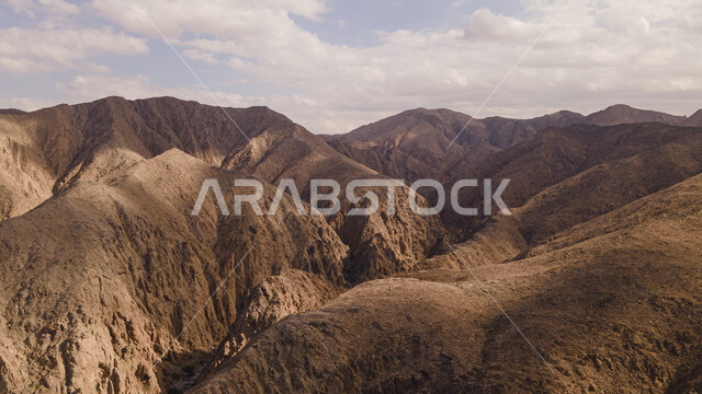 منحدرات الجبال الصخرية الطبيعية في سلطنة عمان، الغيوم والسحب البيضاء في السماء وقت النهار، القمم والمرتفعات الجبلية في ولاية بوشر في محافظة مسقط، معالم ولاية بوشر المشهورة