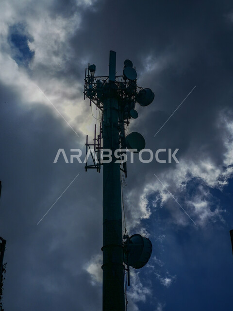 صورة مقربة لبرج جوال في محافظة فيفاء، السماء الملبدة بالغيوم والسحب الشتوية، أعمدة وأبراج الاتصالات المعدنية في السعودية، معالم مدينة جازان 