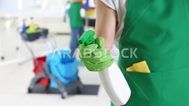 القيام بالمهام والأعمال المنزلية الروتينية, أدوات ومعدات التنظيف, مفهوم النظافة والتطهير, صورة مقربة ليد امرأة عرببة خليجية تستخدم ملمع الزجاج, الاهتمام وحماية المنزل, مستلزمات ومواد التعقيم, الوقاية من الأمراض