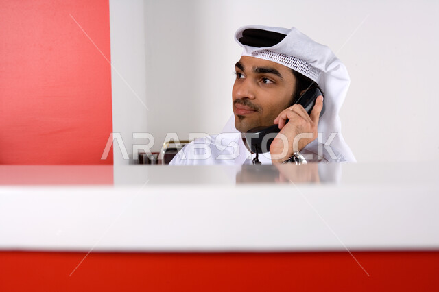 توثيق الطلبات و تأكيد الحجوزات , موظف عربي إماراتي  خليجي يرتدي الغترة التقليدية و يعمل في خدمة العملاء , الرد على الاتصالات والاستفسارات, التواصل الفعال مع العملاء,  تقديم الخدمات المطلوبة والحرص على رضى العميل , بيئة العمل في شركات الإمارات .