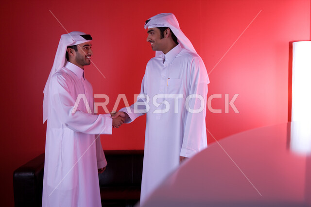 التحية والسلام ، رجلا أعمال عربيان خليجيان إماراتيان يرتديان الزي التقليدي ويقومان بالتصافح ، نقاشات وحوارات واتفاقيات عمل جديدة ، دراسة وتحليل المشاريع المطروحة حديثا ، التعاون بين الشركات للحصول على أفضل الصفقات ، مناقشة ومتابعة أهداف الشركة .