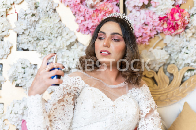 A Saudi Arabian bride sitting on the kosha, wearing incense and oud, wearing a white wedding suit, the night of life, occasions and weddings