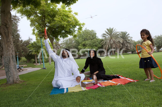 أجواء عائليه مليئه بالحب ، قضاء أوقات ترفيهية وأنشطه ممتعه برفقه العائله، أسرة عربيه خليجيه اماراتية تقوم بالجلوس في الحديقة، النزهات والحدائق الترفيهية في الدول العربيه، الاستمتاع في الهواء الطلق، مفهوم الترابط الأسري وحب الأبناء .