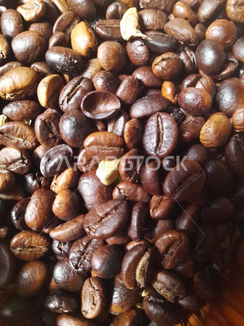 مكونات القهوة العربية, إعداد المشروبات الساخنة, صورة مقربة لحبوب البن المحمصة المتناثرة, بذور القهوة العضوية, منتجات محلية سعودية, جودة الصناعات والمحاصيل الغذائية الوطنية في المملكة العربية السعودية