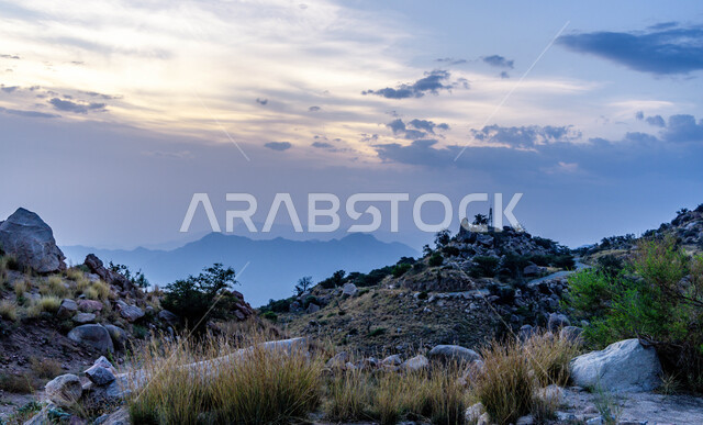 النباتات والاشجار الخضراء على سفوح الجبال، التشكيلات الصخرية على القمم والمرتفعات الجبلية وقت غروب الشمس في منتزه الفرعاء السياحي المشهور في عسير، فعاليات وأنشطة صيفية عائليه متنوعة ، خلفية التضاريس الطبيعيه في السعوديه، منظر السماء المليئة بالسحب البيضاء