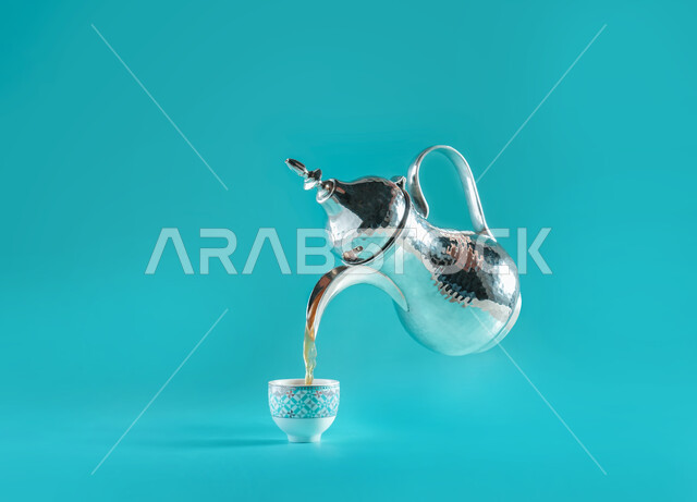 عادات وتقاليد العرب في شرب القهوة, بورتريه لصب القهوة العربية الساخنه في الفنجان الزجاجي, إكرام الضيف وحسن الاستقبال, الضيافة العربية في المملكة العربية السعودية, منتجات محليه وطنية, خلفية زرقاء