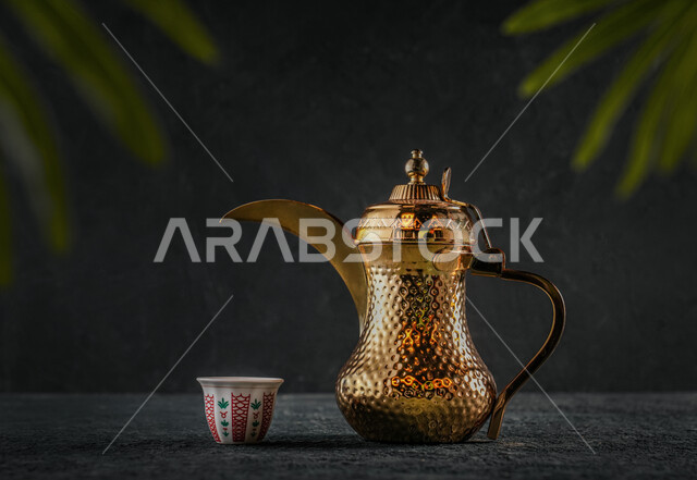 إكرام الضيف وحسن الاستقبال,صورة مقربه لإبريق نحاسي مع فنجان القهوة, العادات العربية القديمة في تقديم القهوة, جودة المنتجات المحلية الوطنية, تقديم المشروبات الساخنة, خلفية سوداء رماديه