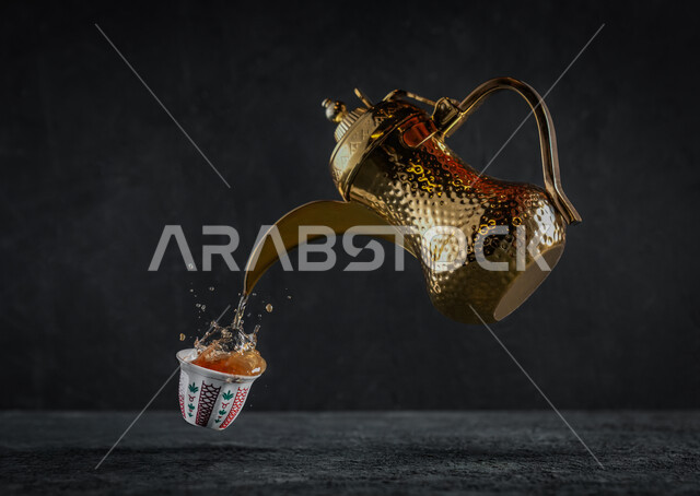 العادات والتقاليد السعودية في الضيافة العربية, صورة مقربة لأبريق نحاسي, صب القهوة الساخنة في الفنجان, دلة قهوة عربية, الاستمتاع في شرب المشروبات الساخنة في الصباح الباكر, خلفية سوداء