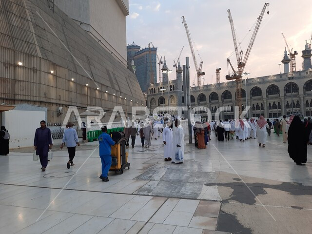 الحجاج في الساحة الخارجية للحرم المكي الشريف في وضح النهار,  تنظيف ساحات الحرم المكي بإستخدام ماكنات ومركبات وآلات التنظيف، طواقم التنظيف في ساحة الحرم المكي الشريف، المسجد الحرام في مكة المكرمة في المملكة العربية السعودية، اماكن ومعالم دينية إسلامية مقدسة