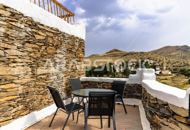 الاستمتاع بالإطلالة المتميزة من شرفات قصور آل أبو نقطة المتحمي التاريخي في منطقة عسير ،النوافذ والحواف العلية المطلية باللون الأبيض في القلاع المطلة على ضفاف وادي طبب ، الحصون الصخرية القديمة ، معالم سياحية أثرية بارزة في  المملكة العربية السعودية .