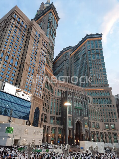 Visitors to the Holy House of God in the outer courtyard of the Holy Mosque, the architectural art of the towers and buildings of the Holy Mosque in Mecca, the arrival of Muslims from all over the world to the Grand Mosque in Mecca, a close-up of the clock tower in Saudi Arabia, Islamic religious landmarks in the Kingdom