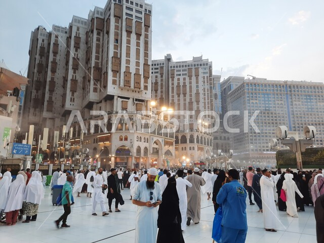 دخول المصلين الى المسجد الحرام لأداء المناسك والعبادات والتقرب الى الله, الفن الهندسي للأبراج المعمارية المحيطة بالحرم المكي, زوار بيت الله الحرام في الفناء الخارجي, قدوم المسلمين من جميع أنحاء العالم إلى مكة المكرمه, المعالم السياحية الدينية المشهورة