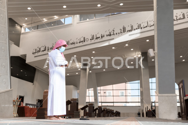 أداء فريضة الصلاه داخل المسجد، رجل سعودي يصلي و يرتدي الكمامة  ، الالتزام باجراءات الوقاية ، العبادة و التقرب الى الله