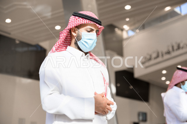 أداء فريضة الصلاه داخل المسجد، صلاه الجماعة لرجلان سعوديان يرتديان الكمامة ، يحافظان على التباعد بينهم ، الالتزام باجراءات الوقاية ، العبادة و التقرب الى الله