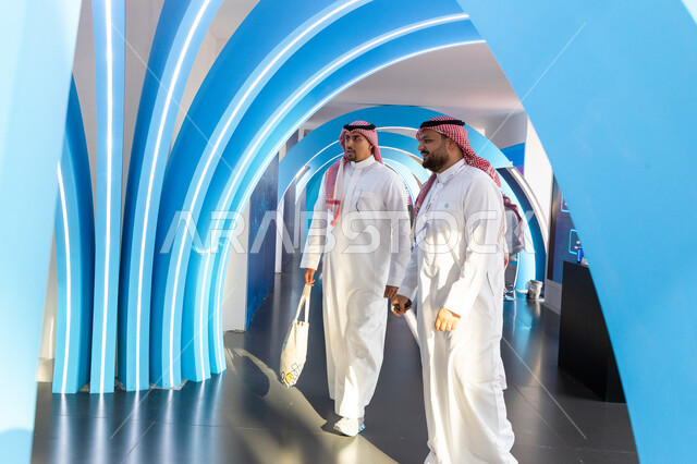 مرشد ومسؤول عربي خليجي سعودي يقوم بالرد على استفسارات زوار معرض سيتي سكيب العالمي، الفرص الاستثمارية في المشاريع السكنية والتجارية، مركز الرياض للمعارض في بلدة ملهم في السعودية، الاستدامة والتخطيط المعماري لقطاع العقارات، رؤية مستقبلية 2030