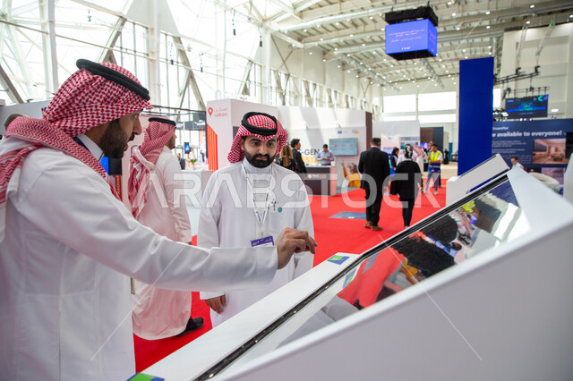 مندوب تسويق عربي خليجي سعودي يقوم بالرد على استفسارات زوار معرض سيتي سكيب العالمي، الفرص الاستثمارية في المشاريع السكنية والتجارية، مركز الرياض للمعارض في بلدة ملهم في السعودية، الاستدامة والتخطيط المعماري لقطاع العقارات، رؤية مستقبلية 2030