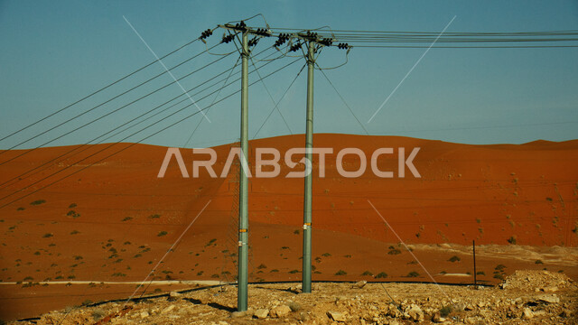 أعمدة وخطوط توزيع الكهرباء في صحراء المملكة العربية السعودية، الاهتمام والتقدم بأعمال البنية التحتية، تزويد وتخديم المناطق النائية بالطاقة الكهربائية، صورة مقربة لبرج نقل كهربائي عالي الجهد 