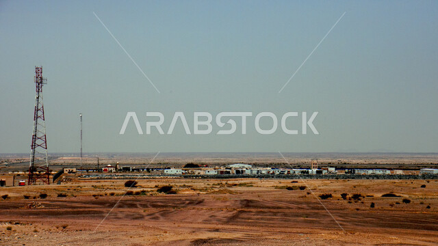 الاهتمام والتقدم بأعمال البنية التحتية، أبراج نقل كهربائي عالية الجهد بجانب المحطة الرئيسية، أعمدة وخطوط توزيع الكهرباء في طريق سريع بين مدن المملكة العربية السعودية، تزويد وتخديم المناطق النائية بالطاقة الكهربائية