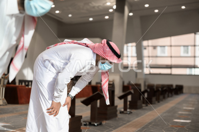أداء فريضة الصلاه داخل المسجد، رجل سعودي يصلي و يرتدي الكمامة  ، الالتزام باجراءات الوقاية ، العبادة و التقرب الى الله