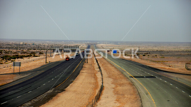 تهيئة البنية التحتية لشوارع السفر في الطبيعة الصحراوية، شاحنة بضائع وسط طريق سفر اسفلتي بين الكثبان الرملية، خط سير سريع وسط الصحراء في المملكة العربية السعودية