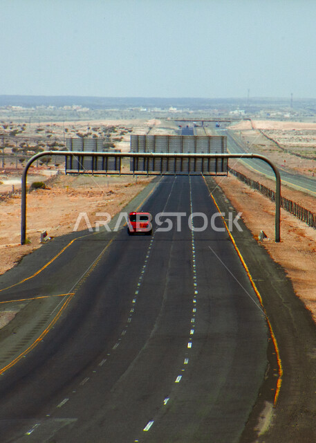 شاحنة بضائع وسط طريق سفر اسفلتي بين الكثبان الرملية، خط سير سريع وسط الصحراء في المملكة العربية السعودية، تهيئة البنية التحتية لشوارع السفر في الطبيعة الصحراوية