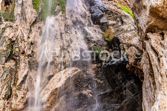 أبرز المعالم الأثرية التاريخيه  في المملكة العربية السعودية، صورة مقربة لشلال مائي طبيعي بين  القمم والمرتفعات الجبليه و الصخرية في منطقة عسير، أماكن سياحية ترفيهية , خلفية الطبيعه