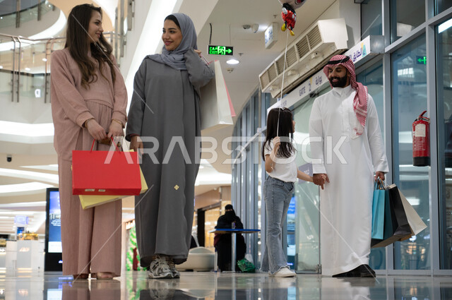 الاستفاده من العروض والخصومات الموسميه, مجموعه من المواطنين العرب الخليجيين السعوديين يتجولون في إحدى المولات التجاريه في المملكة, الاستمتاع في الشراء والتسوق واقتناء المستلزمات والهدايا, قضاء وقت ممتع في الأسواق السعوديه