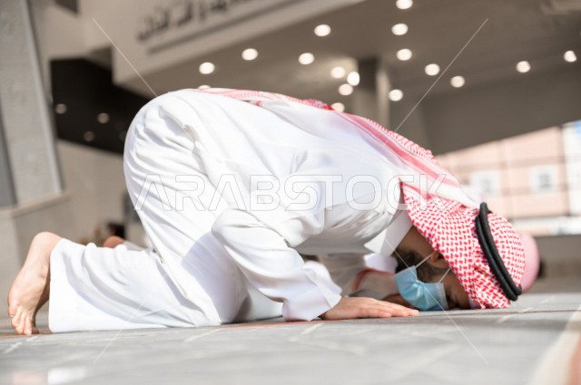 أداء فريضة الصلاه داخل المسجد، رجل سعودي يصلي و يرتدي الكمامة  ، الالتزام باجراءات الوقاية ، العبادة و التقرب الى الله