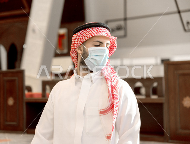 أداء فريضة الصلاه داخل المسجد، رجل سعودي يصلي و يرتدي الكمامة  ، الالتزام باجراءات الوقاية ، العبادة و التقرب الى الله