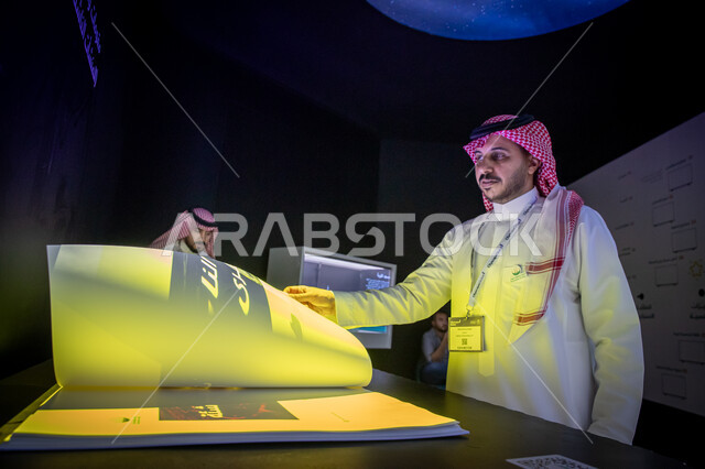 الفرص الاستثمارية في المشاريع السكنية والتجارية، رجل عربي خليجي سعودي يرتدي الشماغ والثوب التقليدي يشاهد معروضات إحدى الاجنحة في  معرض سيتي سكيب العالمي، رؤية مستقبلية 2030، مركز الرياض للمعارض في بلدة ملهم في السعودية، الاستدامة والتخطيط المعماري لقطاع العقارات