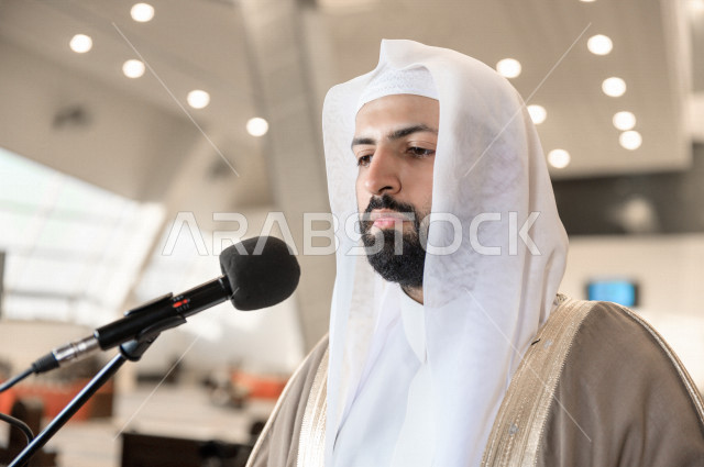 إمام مسجد سعودي خليجي في احدى المساجد بالمملكة العربية السعودية يؤذن بالمصليين على المنبر ، يقيم الصلاه على المصلين  ، دور أئمة المساجد والخطباء عظيم