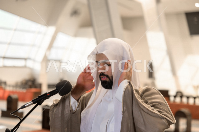 إمام مسجد سعودي خليجي في احدى المساجد بالمملكة العربية السعودية يؤذن بالمصليين على المنبر ، يقيم الصلاه على المصلين  ، دور أئمة المساجد والخطباء عظيم
