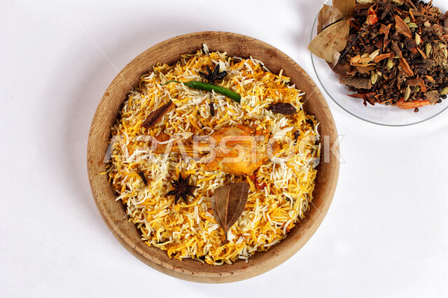 طبق من المندي اللذيذ مع الدجاج , أرز بخاري مبهرمزين بورق الغار الخشن ، أكلات عربية تقليدية،  وصفات وأطباق طعام شهية،  مطاعم ومطابخ شرقية سعودية , خلفية بيضاء 