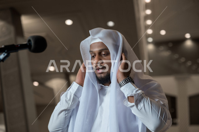 إمام مسجد سعودي خليجي في احدى المساجد بالمملكة العربية السعودية يؤذن بالمصليين على المنبر ، يقيم الصلاه على المصلين  ، دور أئمة المساجد والخطباء عظيم