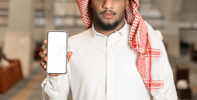 رجل سعودي خليجي مسلم داخل احدى المساجد في المملكة العربية السعودية ،يحمل بيده هاتفه المحمول ،العبادة و التقرب الى الله 