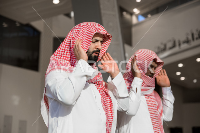 Performing the obligatory prayer inside the mosque, two Saudi men pray in the prayer hall, reverence in the prayer, performing the obligatory prayer in the mosque, worship and draw close to God