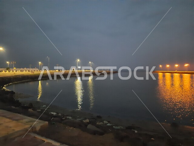 منظر لانعكاس الانارة و الاضواء على سطح البحر الأحمر في محافظة القنفذة، وجهه ساحلية سياحية مشهورة، الاطلالة البحرية للكورنيش في وقت الليل، اماكن ترفيهية عائلية في المملكة العربية السعودية، الاهتمام بالبنية التحتية وتحسن الخدمات والمرافق العامة في المدينة