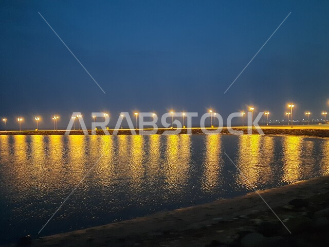 منظر لانعكاس الانارة و الاضواء على سطح البحر الأحمر في محافظة القنفذة، وجهه ساحلية سياحية مشهورة، الاطلالة البحرية للكورنيش في وقت الليل، اماكن ترفيهية عائلية في المملكة العربية السعودية، الاهتمام بالبنية التحتية وتحسن الخدمات والمرافق العامة في المدينة