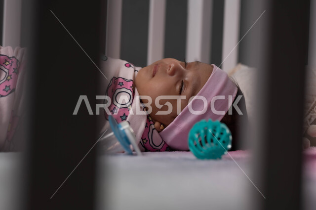 مفهوم تدفئة الرضيع بالتقميط، ايماءات الأمان والراحة، صورة مقربة لطفلة رضيعة عربية خليجية سعودية نائمة بهدوء وسعادة، أهمية الراحة والنوم، الشعور بالتعب والنعاس، مفهوم البراءة والطفولة، الحفاظ على الدفء والأمان للرضع