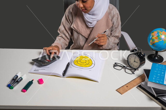 أهمية التعليم في بناء مستقبل مشرق للمجتمع السعودي , طالبة جامعية تقوم بتأدية المشاريع والواجبات  , بورتريه لفتاه عربية خليجية سعودية محجبة ترتدي العباءة و تستخدم الآلة الحاسبة للتأكد من نتائج بحثها, إيماءات الإجتهاد والاهتمام بالعلم والتعلم ,   خلفية سوداء .