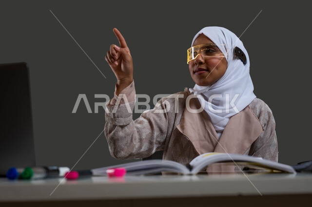 The concept of distance education with modern technology and technology, a close-up portrait of a veiled Saudi Arabian Gulf girl wearing an abaya and 3D smart glasses, clicking and pointing at something, interacting and merging with study via virtual reality, black background