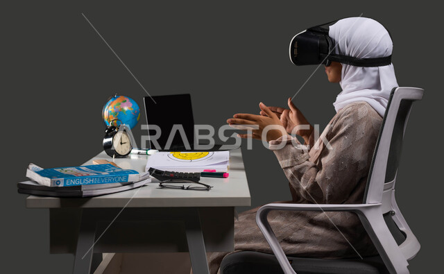 المشاركة والانسجام بإيماءات التحجيم ومحاولة إمساك عنصر ما والتفاعل مع المحتوى الافتراضي، التعلم التفاعلي عبر الانترنت، بورتريه من الجانب لطالبة ثانوي عربية سعودية خليجية محجبة ترتدي عباءة وتضع نظارات في آر ثلاثية الابعاد، خلفية سوداء